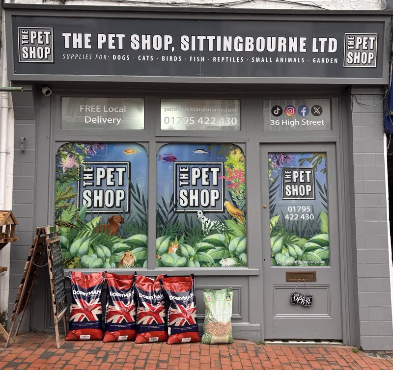 The shop frontage on Sittingbourne High Street with painted window murals and sacks of pet food stacked outside
